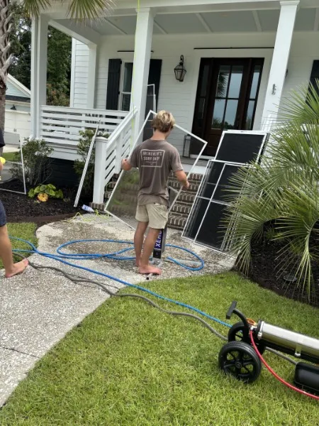 Clear Current cleaning window screens outside a home